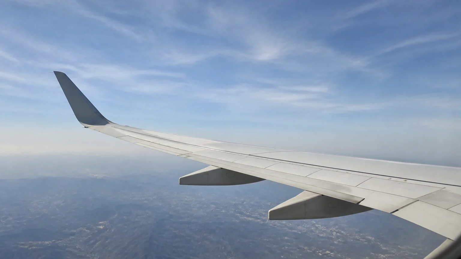 飛行機の窓から見える翼と青空